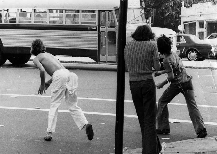 Two boys threw objects at a bus carrying Black students at Edward Everett Square in Dorchester on Sep. 12, 1974, the first day of school under the new busing system put in place to desegregate Boston Public Schools.  (Jack O'Connell/Globe Staff)