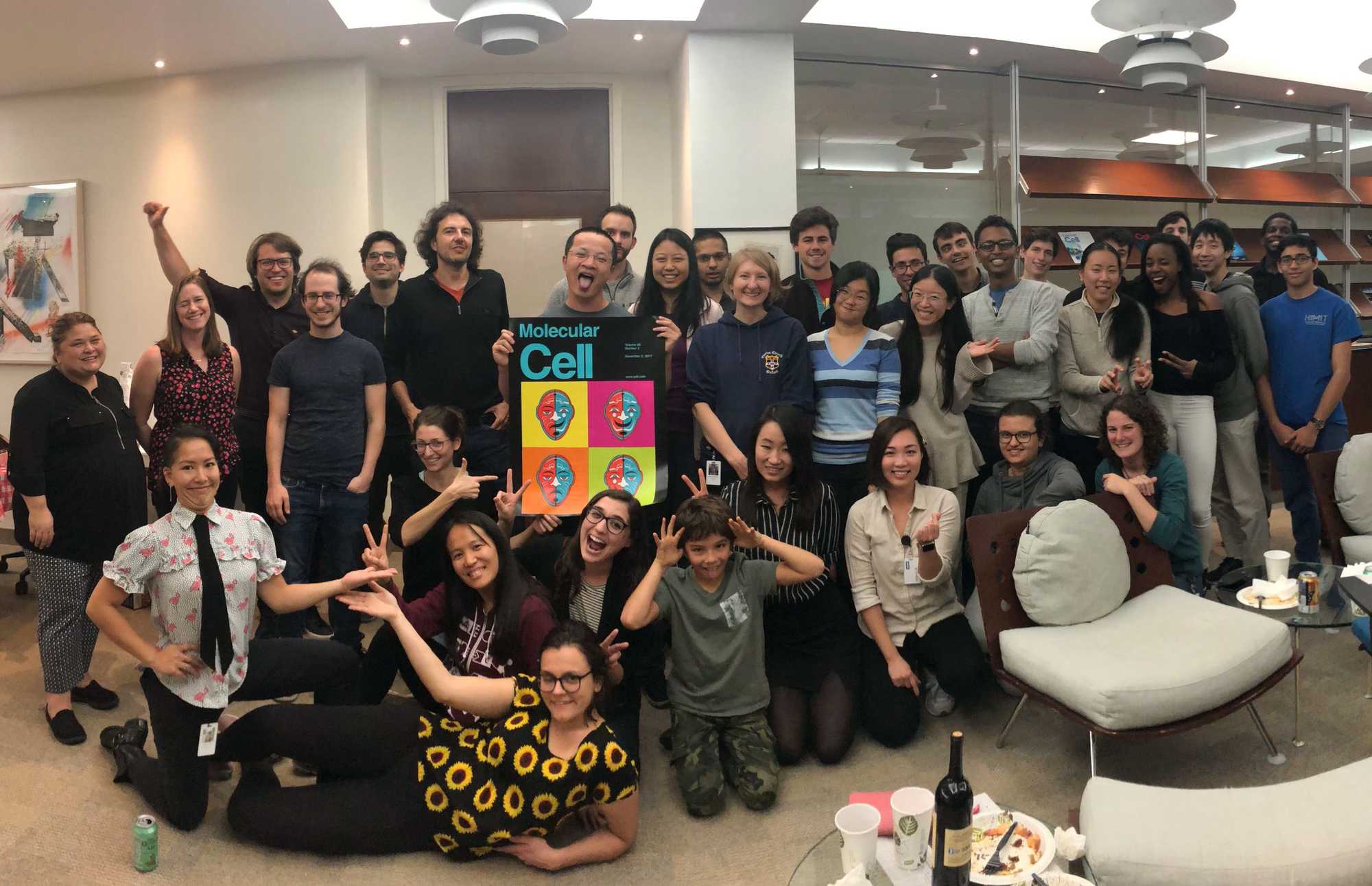 David Sabatini, standing to the left of the poster, and his lab members often paused to mark the personal and professional milestones of its members. In this case, the lab joins a colleague in celebrating a scientific paper appearing in a prestigious journal.
