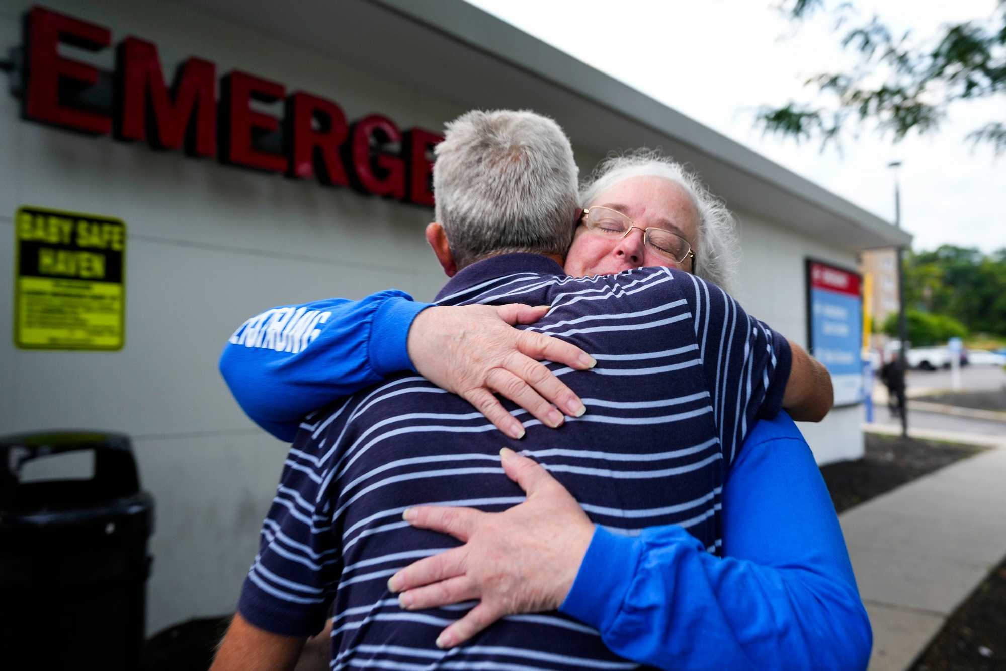 Carney Hospital lead department secretary Maryanne Murphy (right) hugged her co-worker Scott Beckman on the last day at the emergency department at Carney.