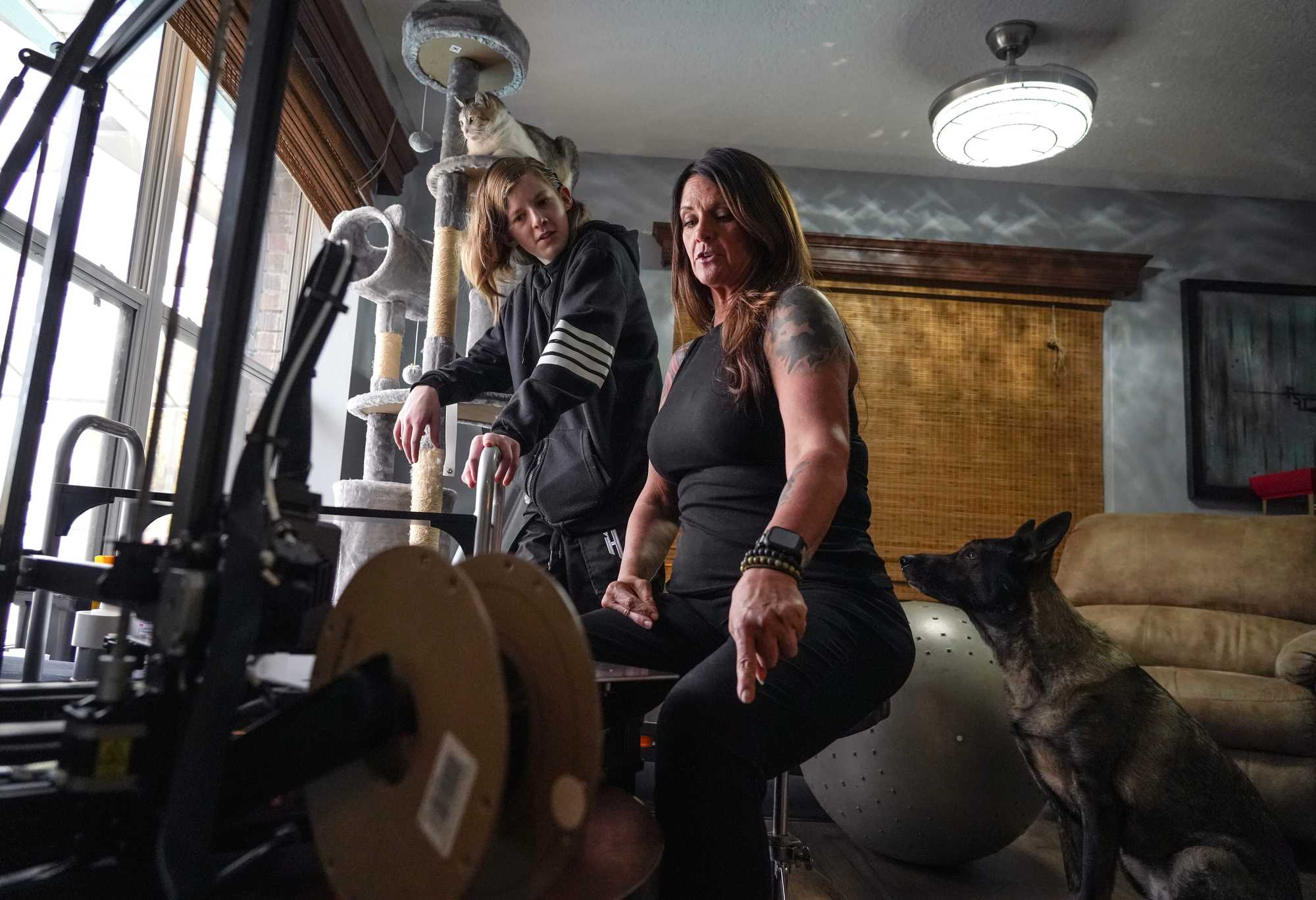 Melissa Williams and her son, Steen Fancher, 14, try to diagnose the problem with the 3D printer at the home they are staying at in Melbourne.  