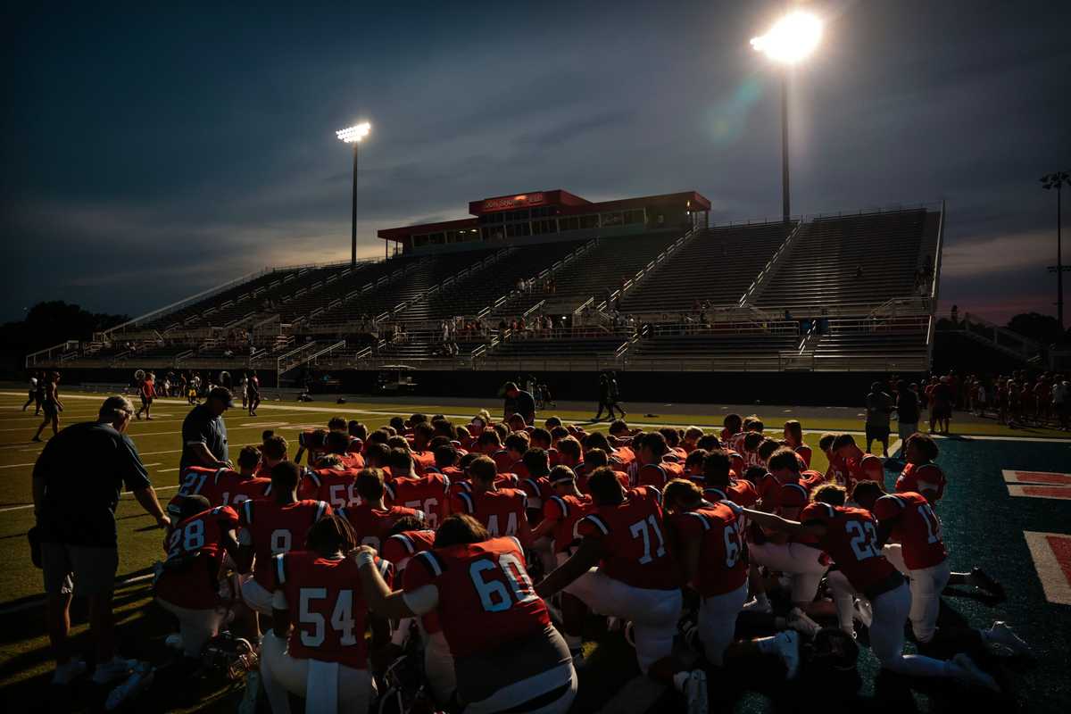 West Monroe High School junior varsity football players kneel in prayer after their game at Rebel Stadium in West Monroe, LA on August 28, 2024.