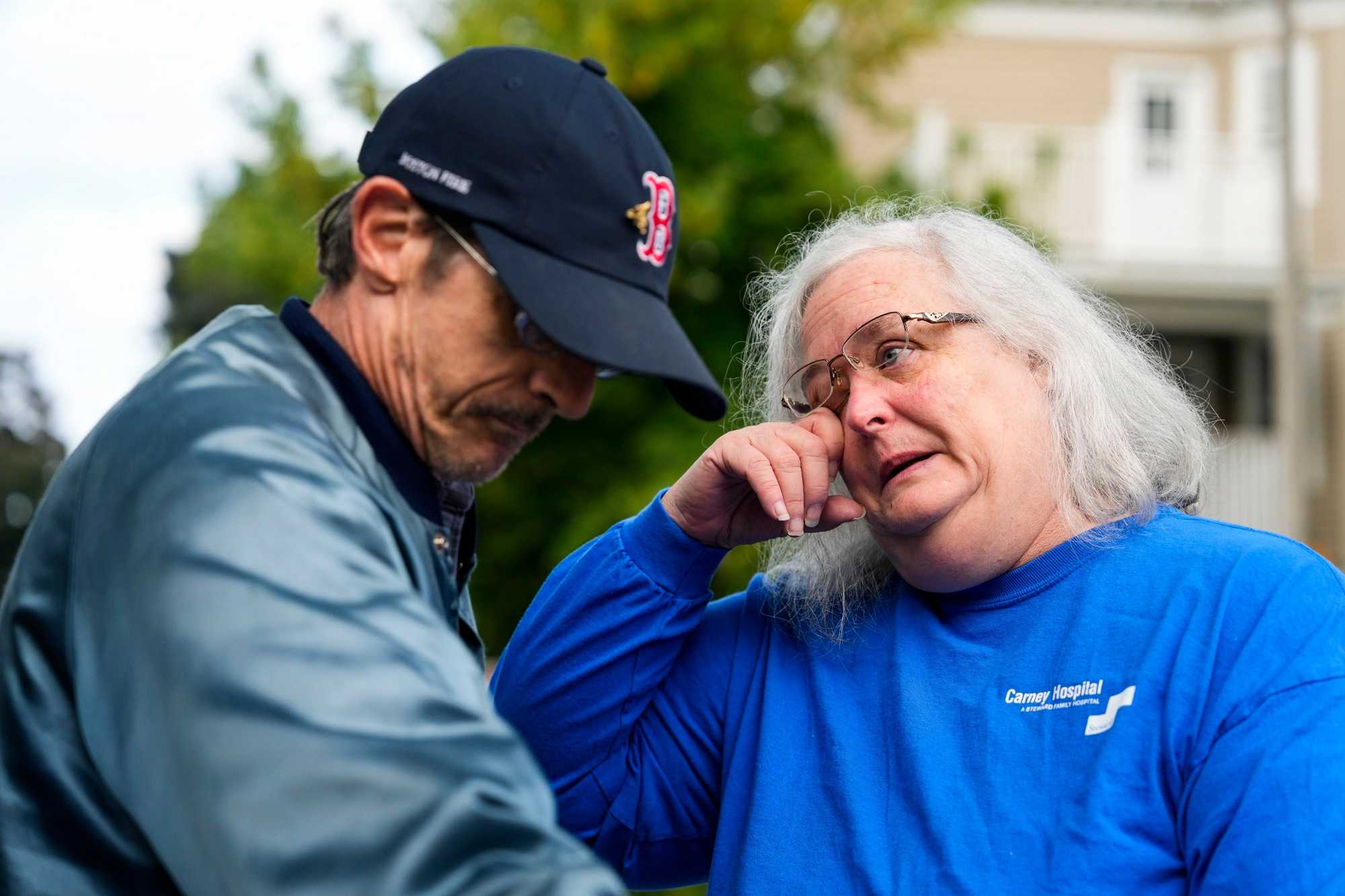 Lead department secretary Maryanne Murphy wiped away tears after hugging a patient, Mike Clark, on the last day at the emergency department at Carney Hospital in Dorchester on Aug. 31.