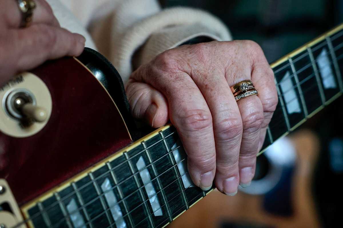 Joan Shea displays her wedding ring and one of her husband’s favorite guitars at her home in West Bridgewater on September 4, 2024.