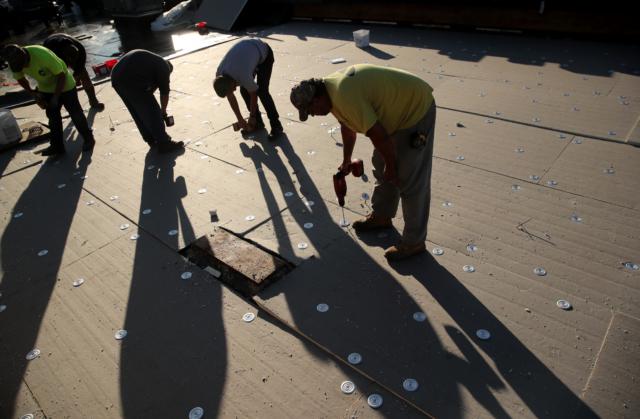 Sub forman Harold Klinzing, right, of McCreary Roofing works atop a building at the Union City School District in Union City.