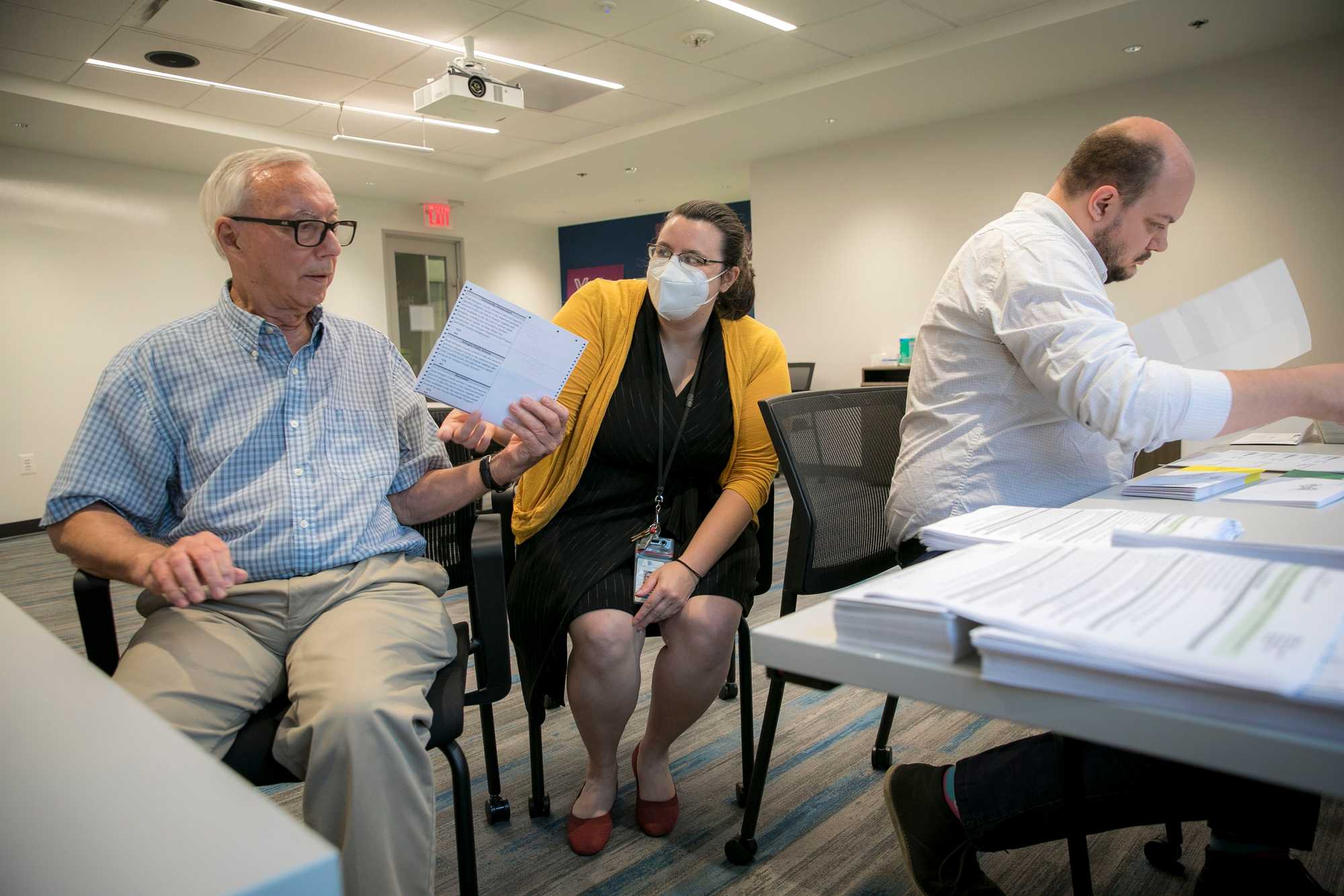 Gretchen Reinemeyer (center), general registrar of elections for Arlington County in Virginia, prepared absentee ballots with Wes MacAdam (left), a seasonal employee, and Reuben Howard, absentee coordinator.