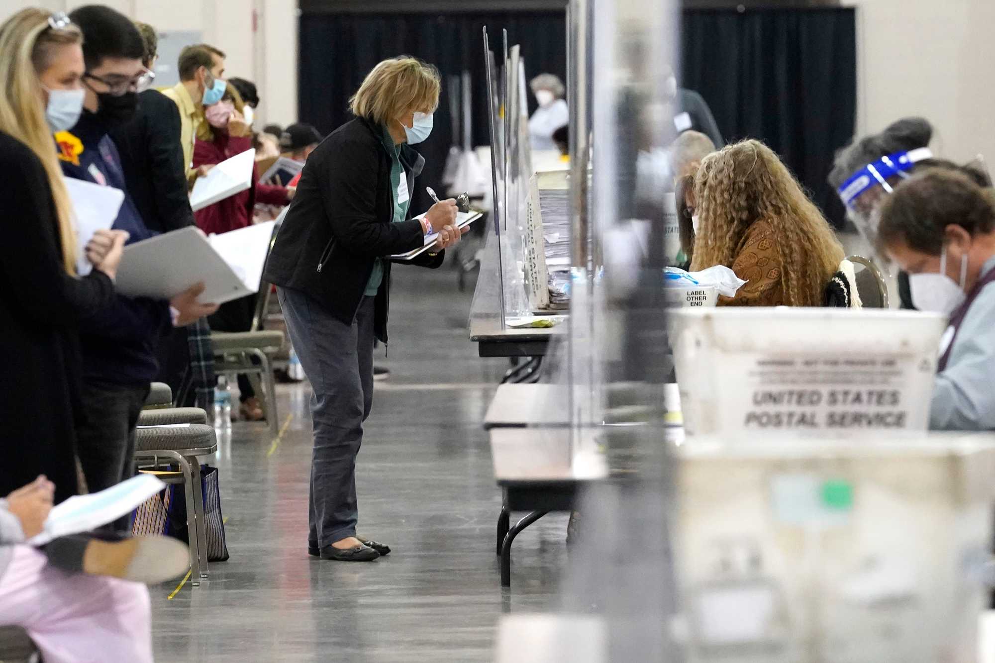 Recount observers watched ballots during a hand recount of presidential votes at the Wisconsin Center, Nov. 20, 2020, in Milwaukee.