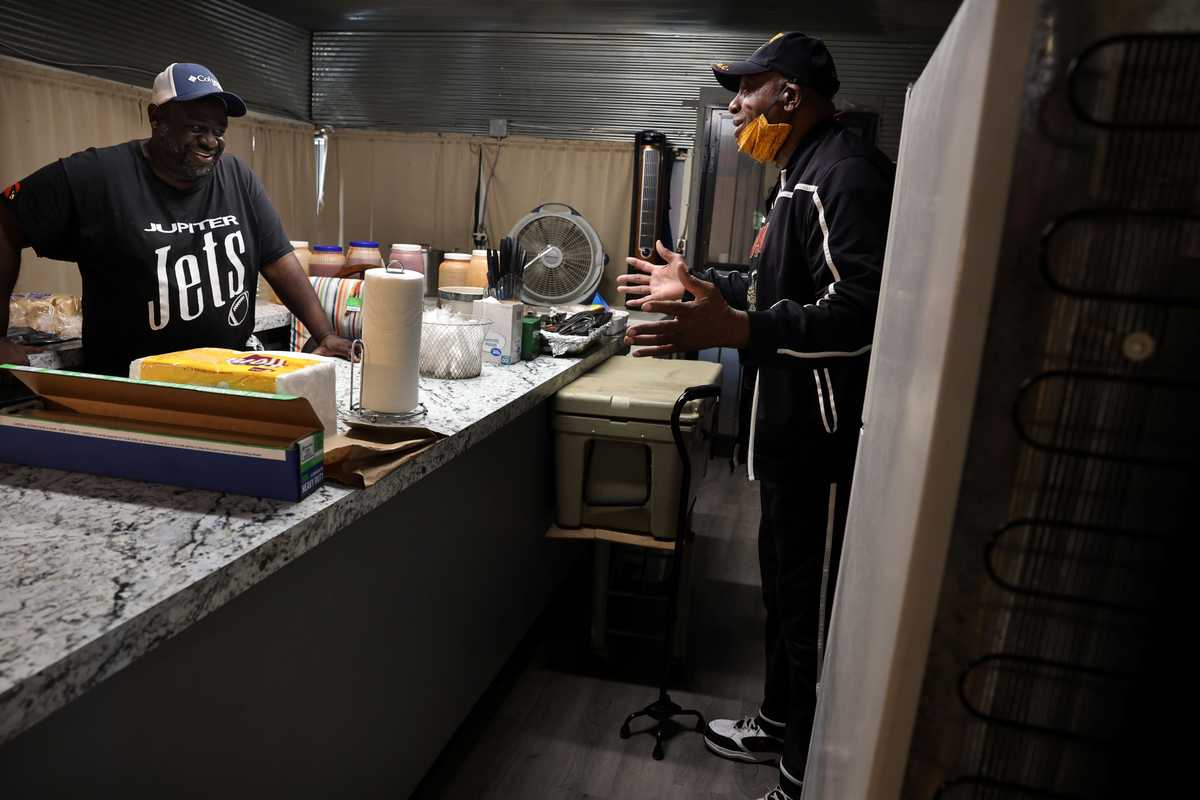 Jones Jr. (left) talked with his cousin Irish Williams while he worked.