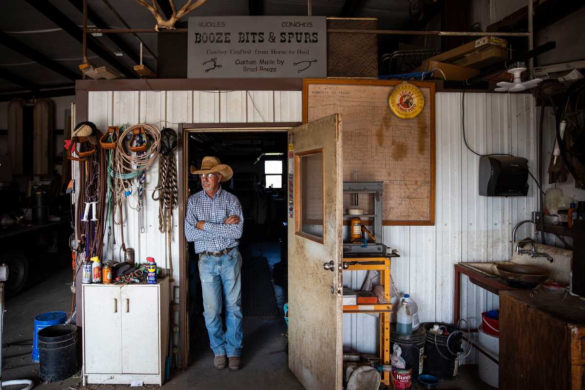 Brad Booze stood in his workshop where he makes custom boot spurs and belt buckles. 