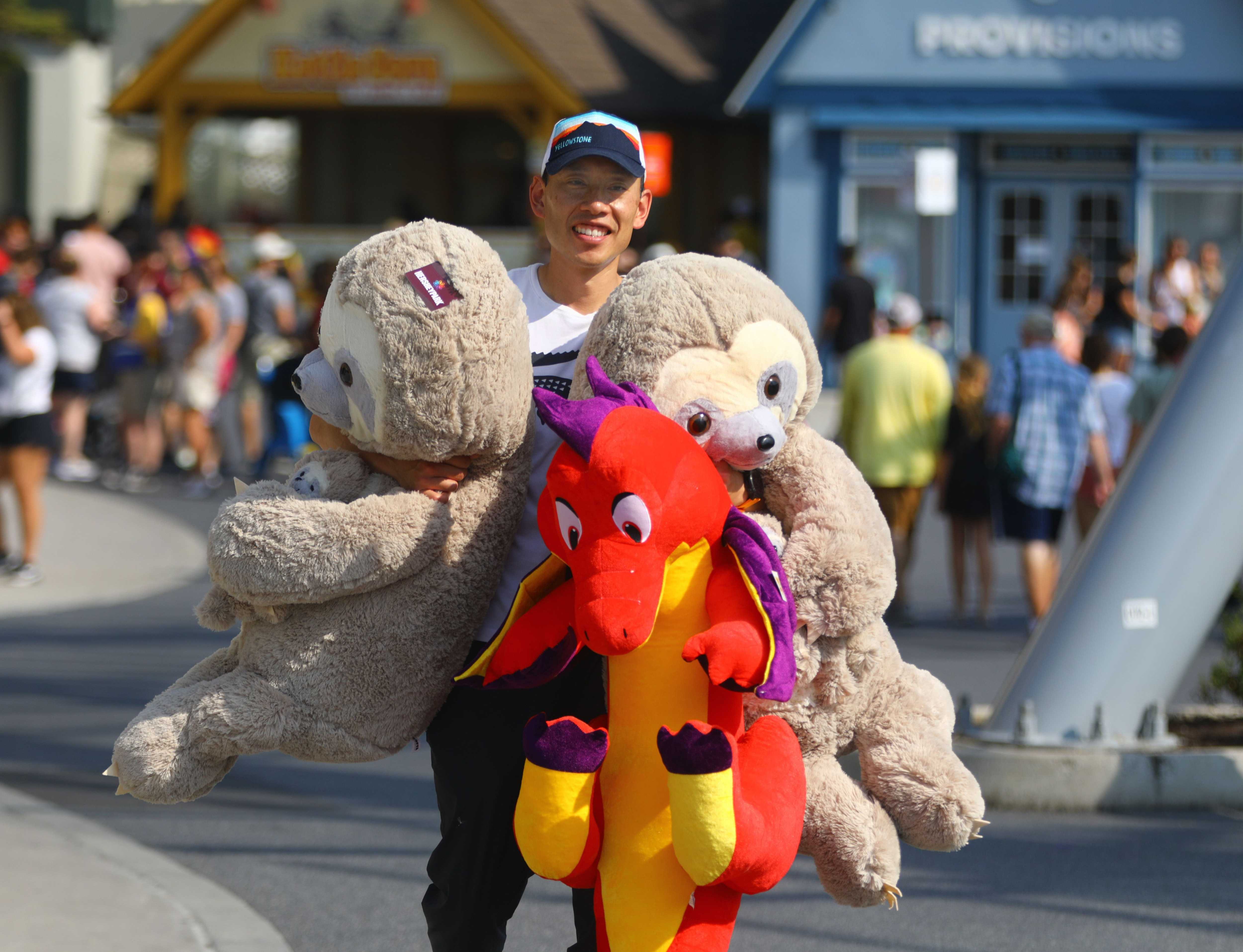 Lawrence Ho headed to his car to deposit trophies from playing carnival games at Hersheypark. He says his career as an eye surgeon gives him an edge when playing the games.