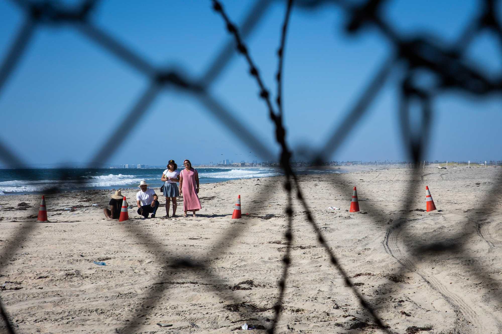 A family stands on the San Diego side of the border wall, looking into Tijuana. Visitors are kept back about 50 feet, prohibiting families and friends from contact. 