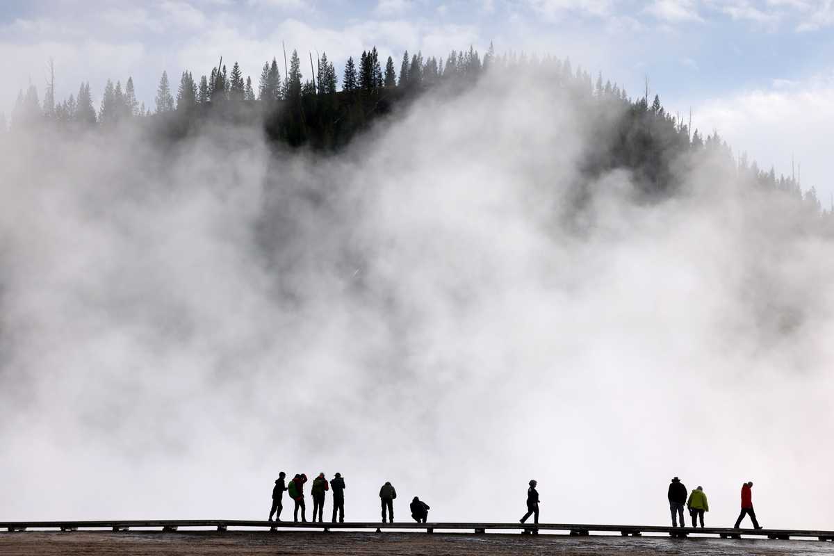 Visitors were silhouetted against the rising steam from the Grand Prismatic Spring as they snapped photos in Yellowstone National Park. 