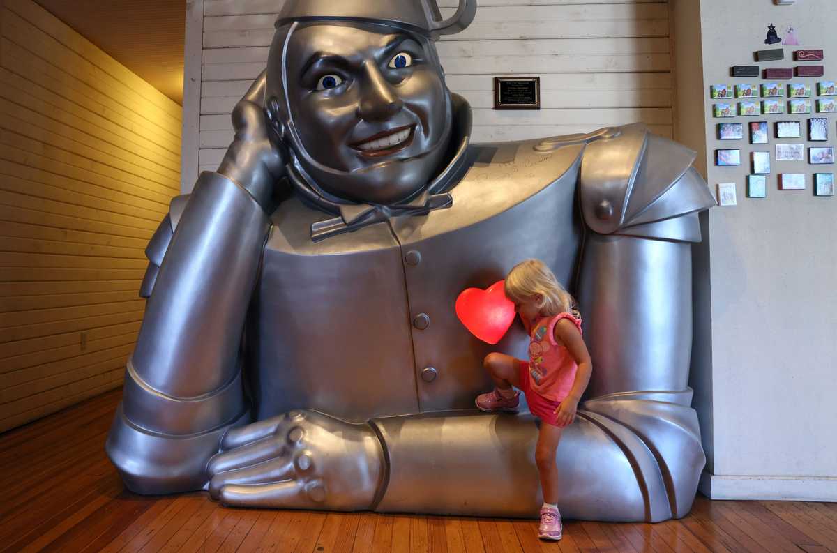 Hadley, a 2 1/2-year-old from Eudora, Kan., climbed up to touch the Tin Man’s heart inside the OZ Museum.  