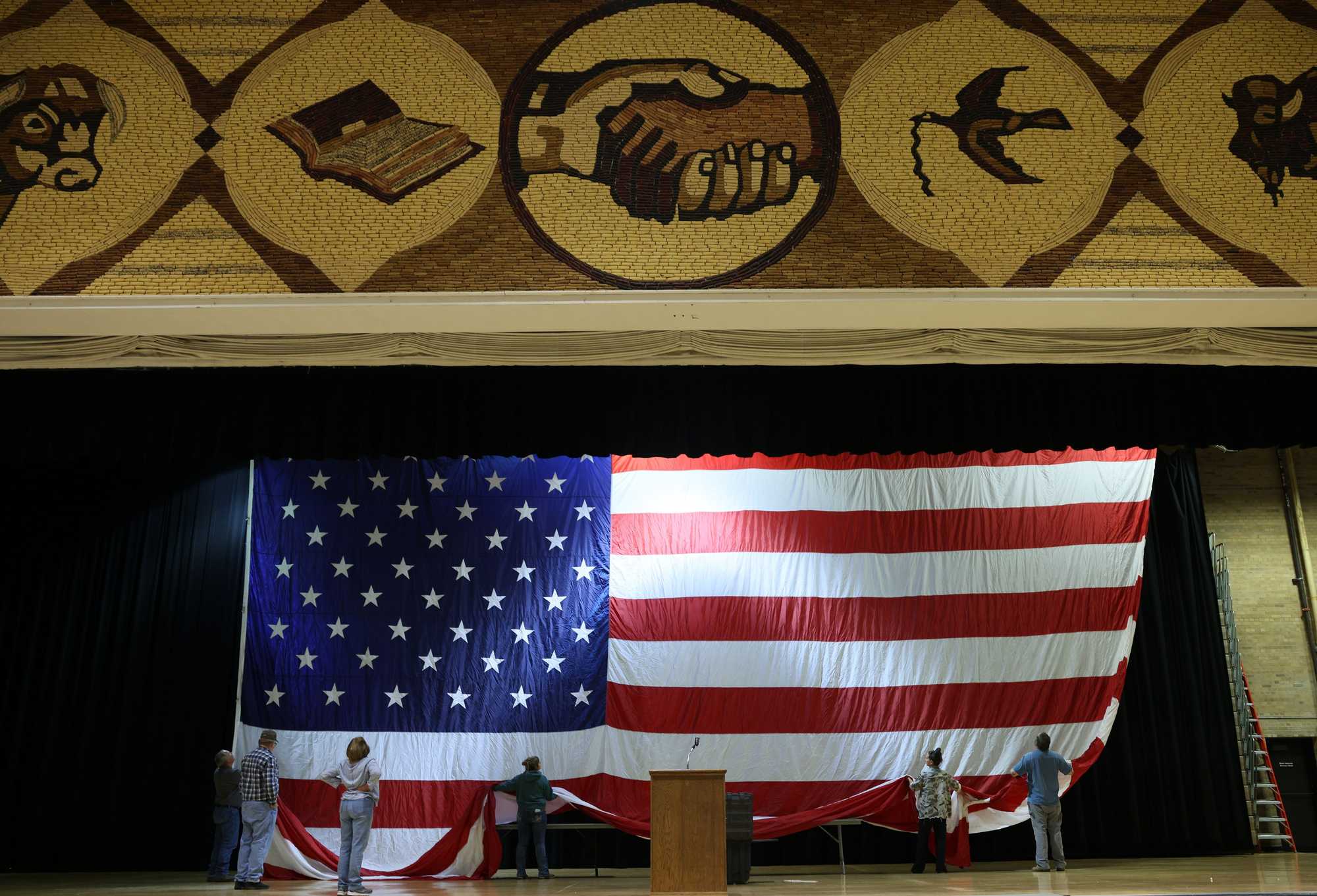 A group of people hung a giant American flag for a meeting of the Mitchell Friends of NRA meeting that was scheduled to take place inside the Corn Palace's convention center. 
