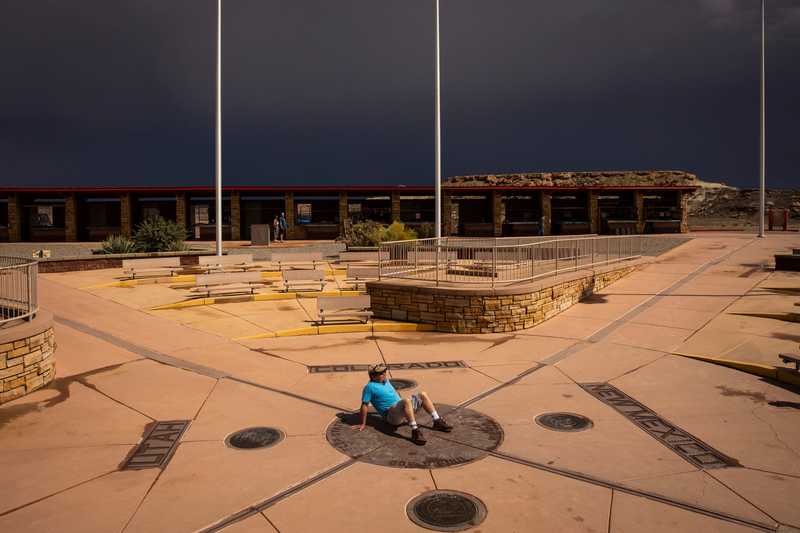 A visitor posed in four states (New Mexico, Utah, Colorado, and Arizona) at one time while visiting Four Corners Monument.