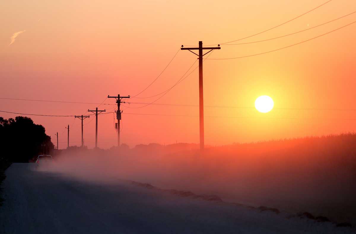 A truck kicked up dust as it navigated a side road at sunset in Wamego, Kan.   