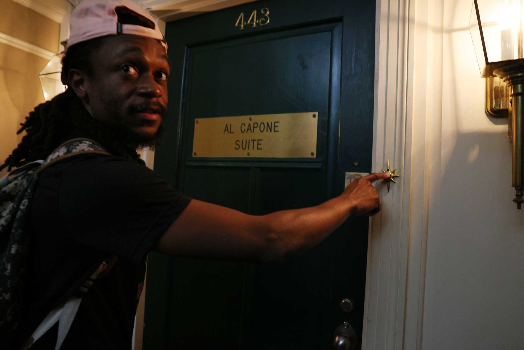 Globe staffer Julian Benbow rings the doorbell outside the Al Capone Suit at the Hot Springs hotel.