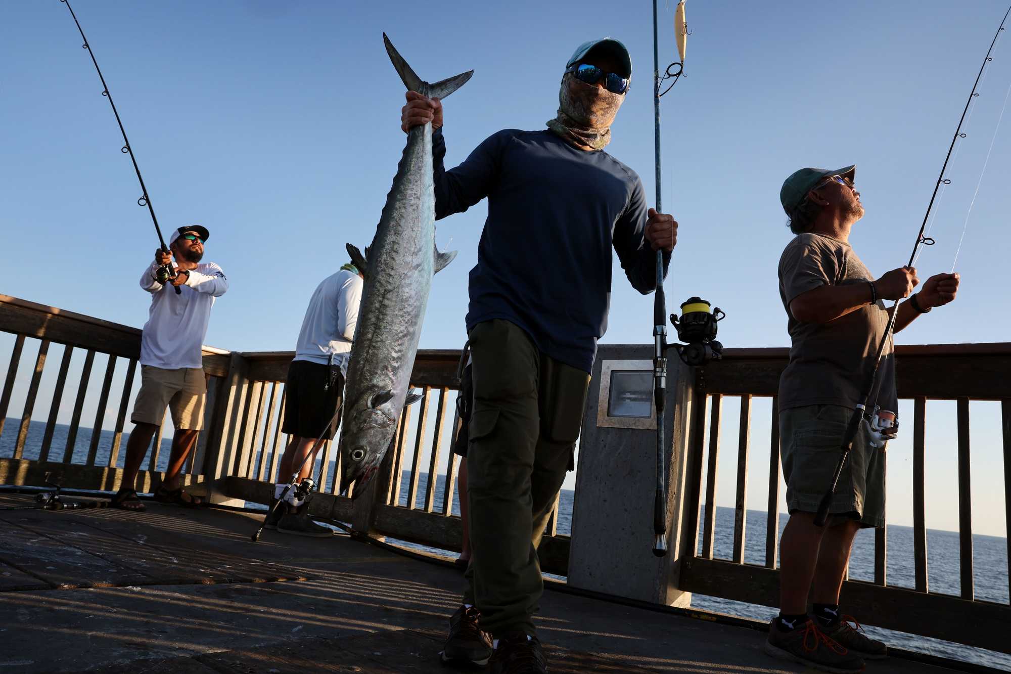 Dat Phan carried the king mackerel he caught while fishing off the city pier in Panama City Beach.