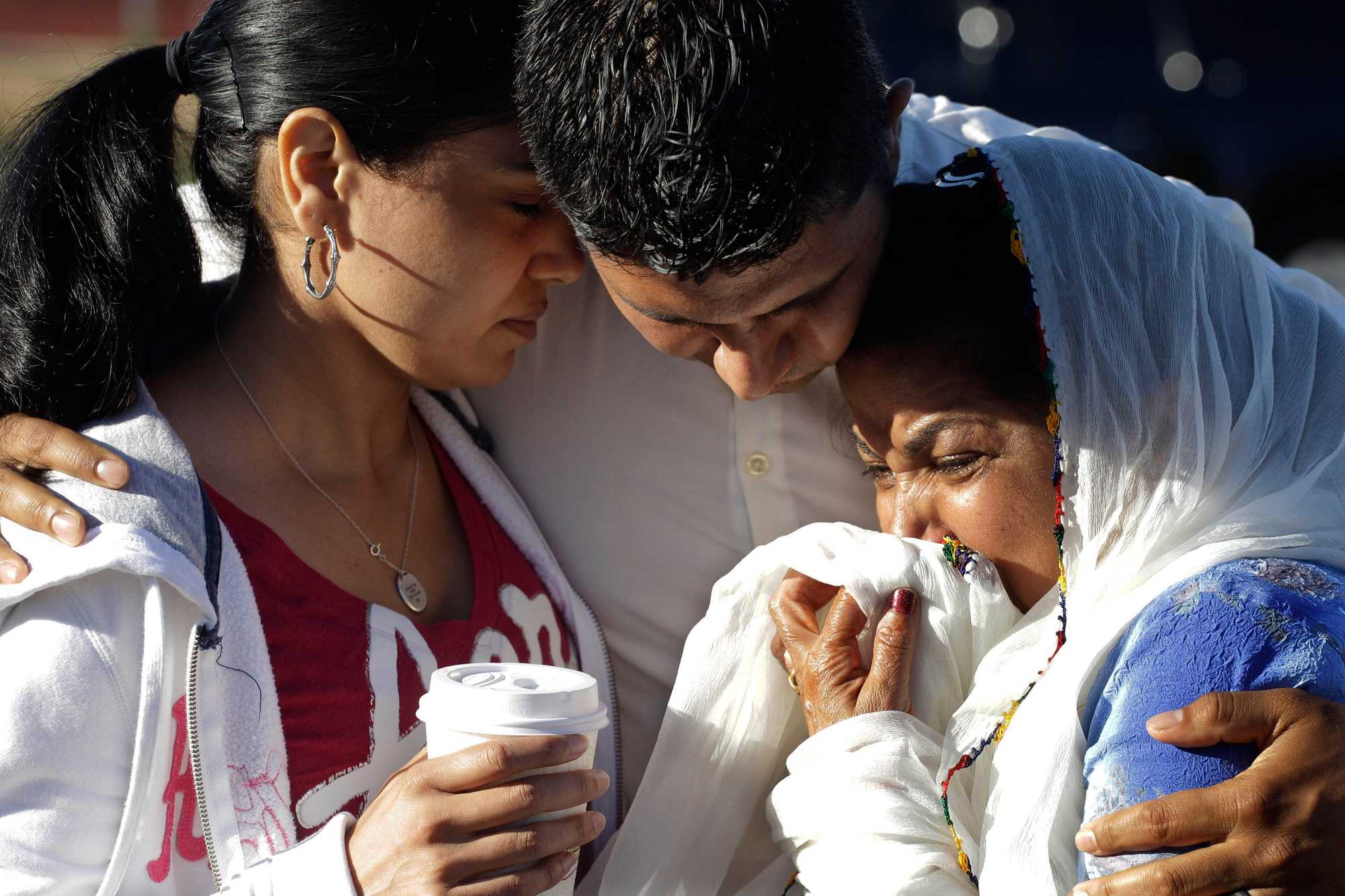 Amardeep Kaleka (center), son of the president of the Sikh Temple of Wisconsin, comforted members of the temple after the shooting. Satwant Kaleka, 65, founder and president of the temple, died in the shooting. He was among four priests who died. 