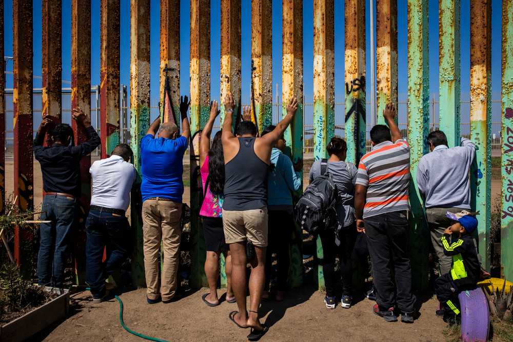 Congregants prayed along the border wall while attending The Border Church, or La Iglesia Fronteriza, on a Sunday in September in Tijuana, Mexico.