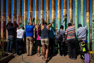 Congregants prayed along the border wall while attending the Border Church / La Iglesia Fronteriza in Tijuana, Mexico.