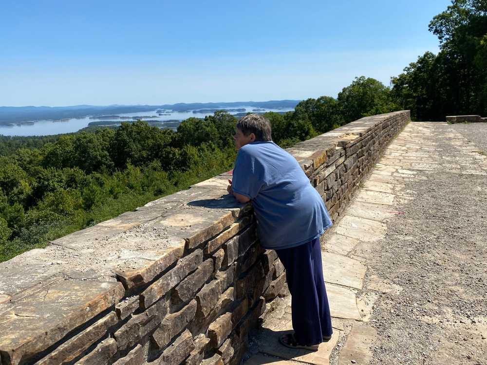 Merrilyn Mann stood at one of her favorite places — Hickory Nut Mountain, the part that overlooks Lake Ouachita. It’s a trip, 23 miles west of Hot Springs, Ark. It’s a slice of peace for her. “The area is very serene, very quiet,” she said.
