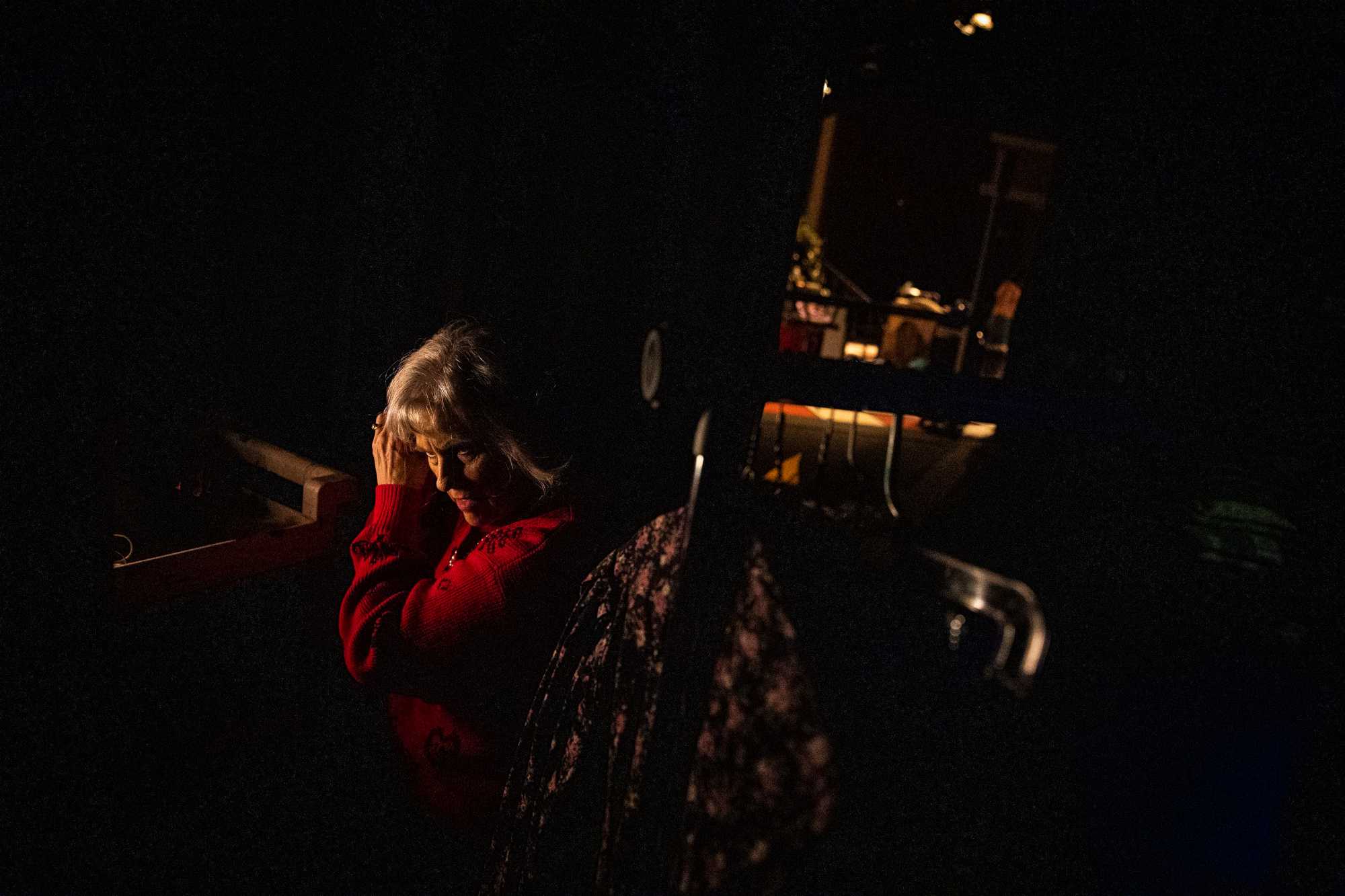 Gayla Rodenbur curled her hair in the backstage shadows while getting ready for her scene during a dress rehearsal .