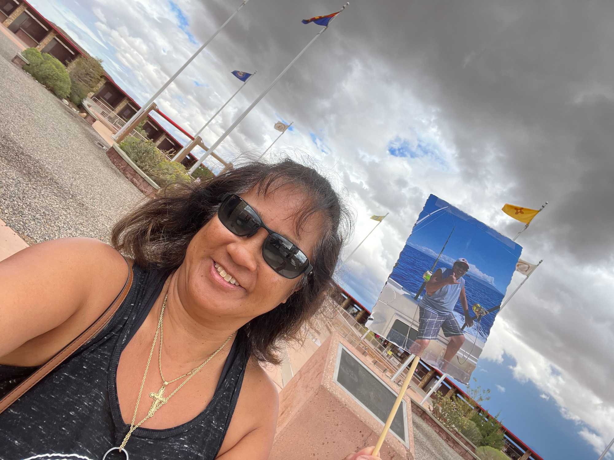 Sherry Masulit-Alcala held a photo of her late husband while taking a selfie at the Four Corners Monument.



