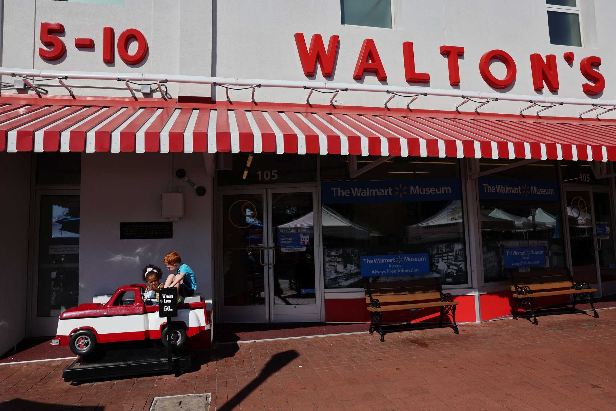 Emerald Edwards, 3 (left), and her brother Hunter, 4, played on a mechanical replica of Sam Walton’s truck outside the Walton's 5 & 10, part of the The Walmart Museum in Bentonville, Ark.