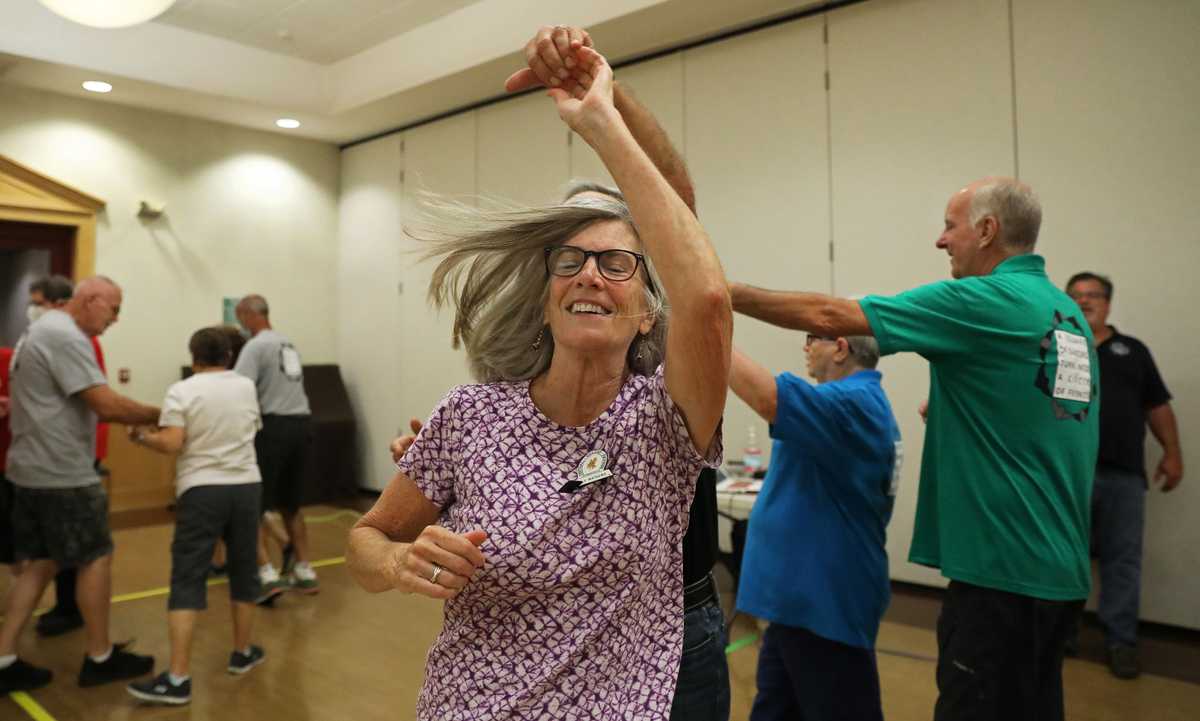 Holly Mathews (center) is twirled during dance lessons at the Central Valley Squares Dance Club in the Farmington Community Center in Unionville, Conn., on Sept. 19.  