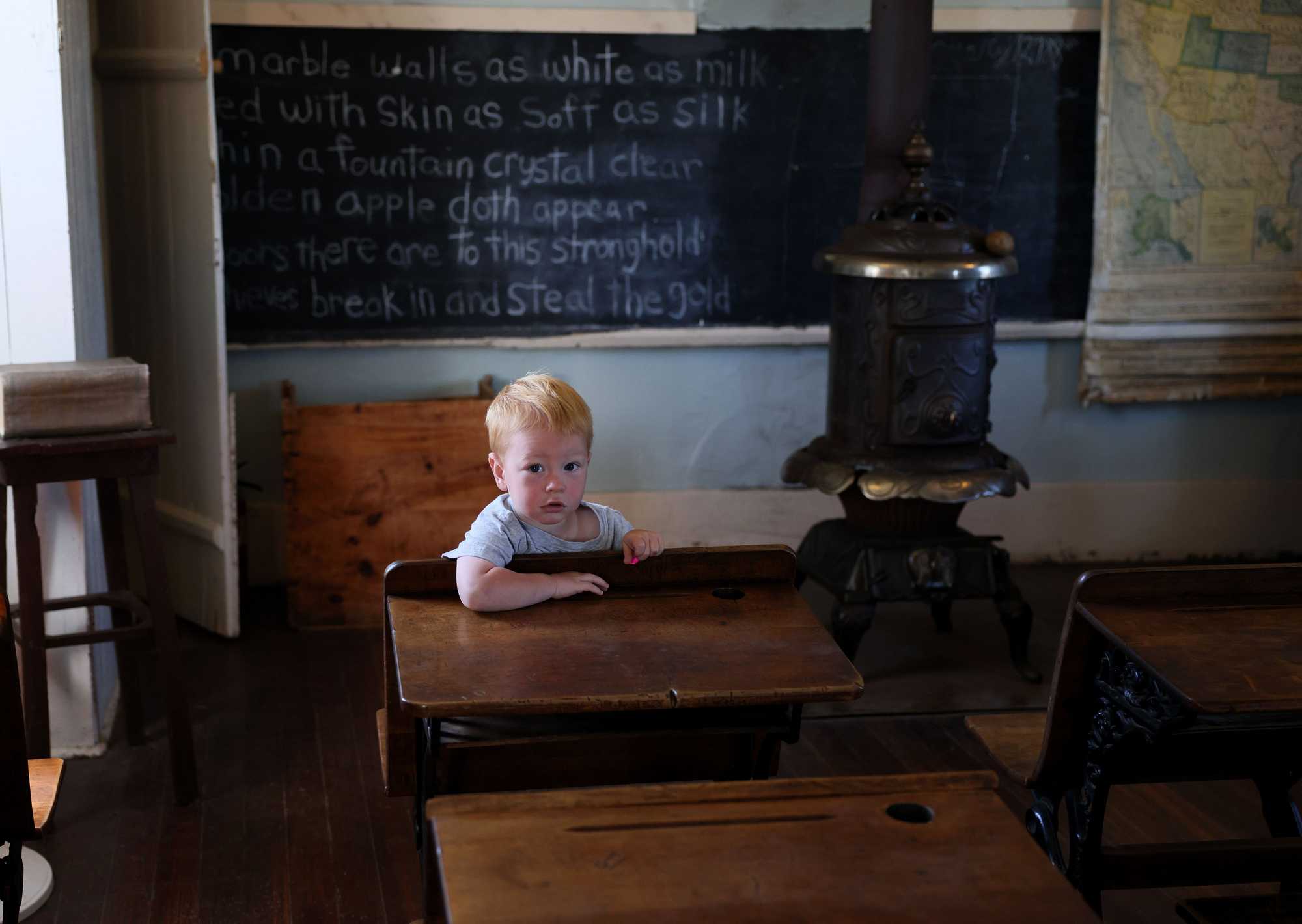 Two-year-old Peter Steinbart took a seat at a desk inside the schoolhouse at the Laura Ingalls Wilder Homestead. 