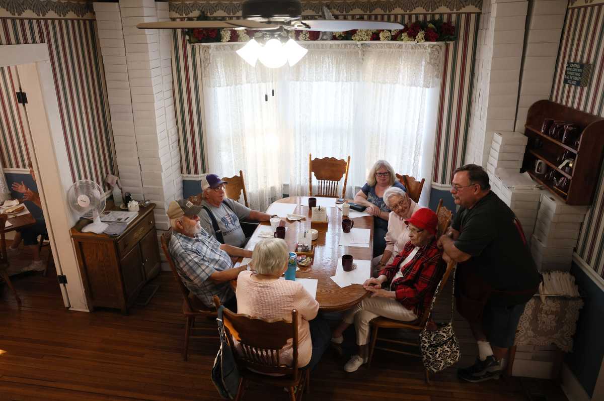 Mike Pray (right), owner of the Friendship House bakery, stopped to chat with members of a breakfast club who have a standing 8 a.m. breakfast date. Pray said the group has been having breakfast about every day for 13 years, except during the pandemic. 