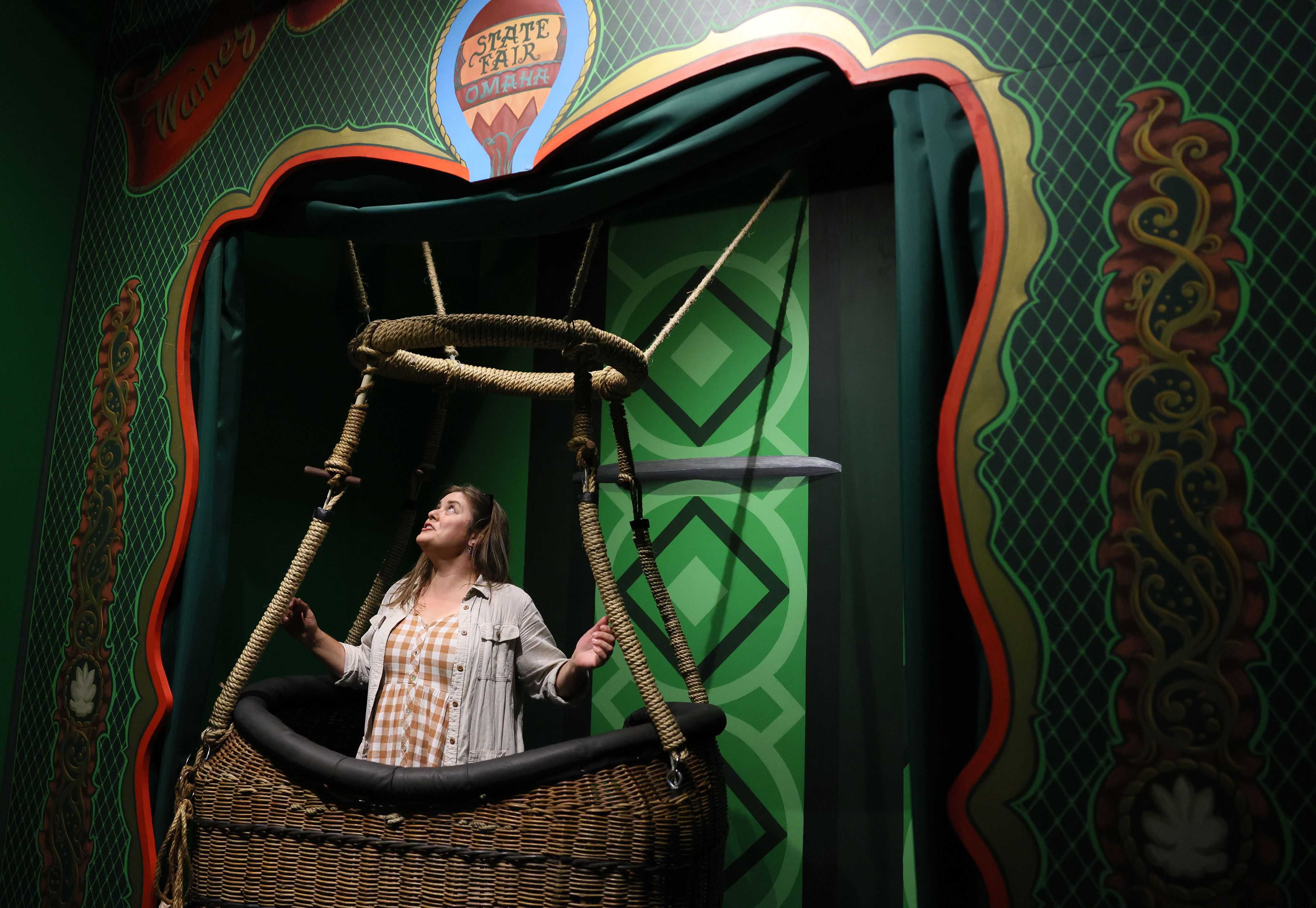 Laura Fredrickson looked up as she stepped into the basket of a hot air balloon to pose for a picture inside the OZ Museum.