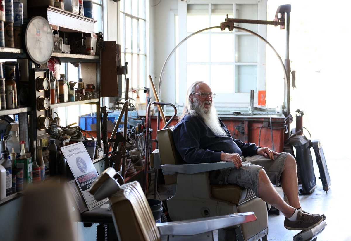 Buddy Eaves, of Hermiston, Wash., hung out inside Greiner’s Radiator Exchange in Walla Walla, Wash., on Sept 19. The shop has the feeling of a museum with collected objects displayed behind glass cases and barber chairs arranged for people to drop by and visit. 