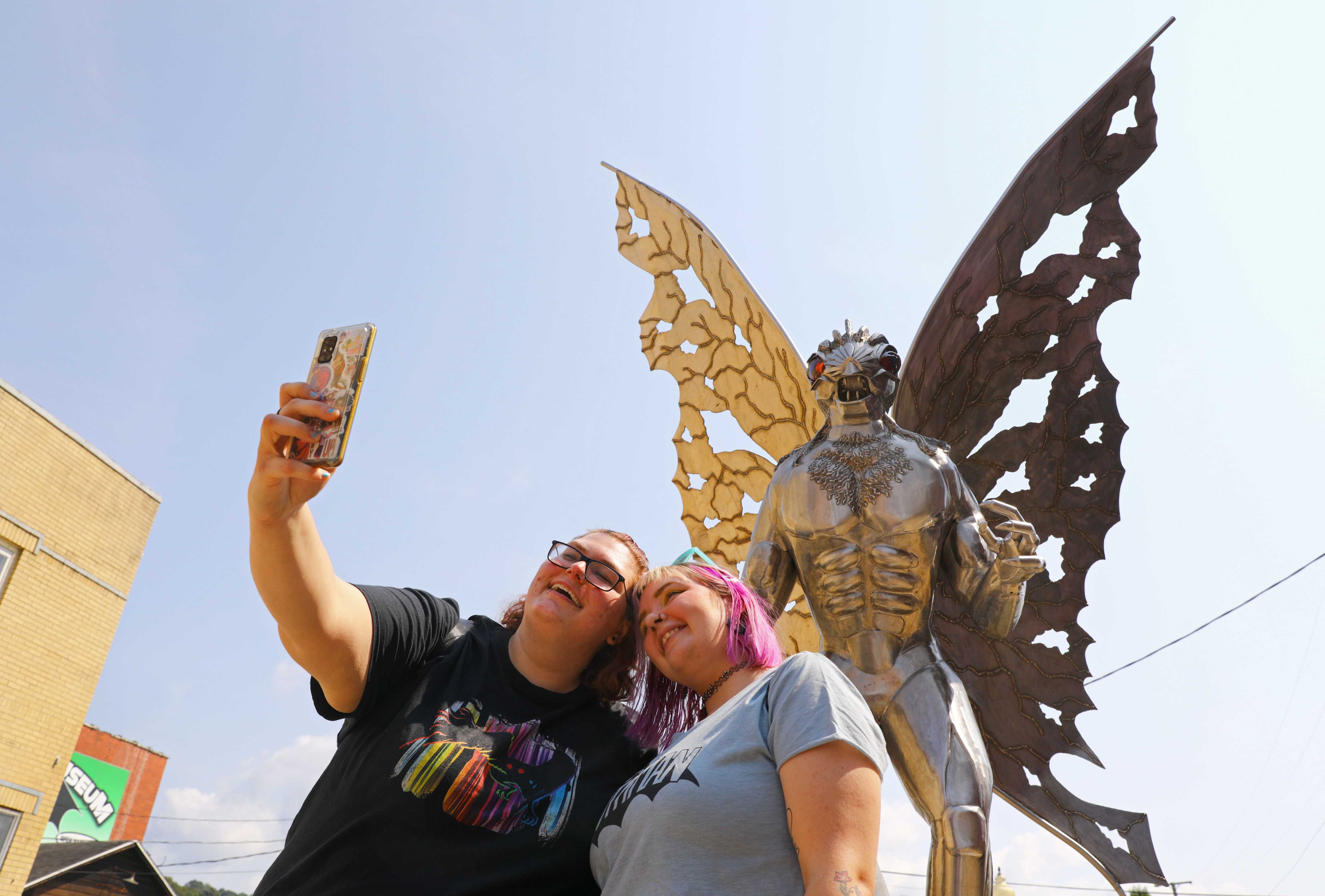 Renly Lee (left) of Fostoria, Ohio, and Trina Rosenberg took a selfie in front of Point Pleasant's Mothman statue.