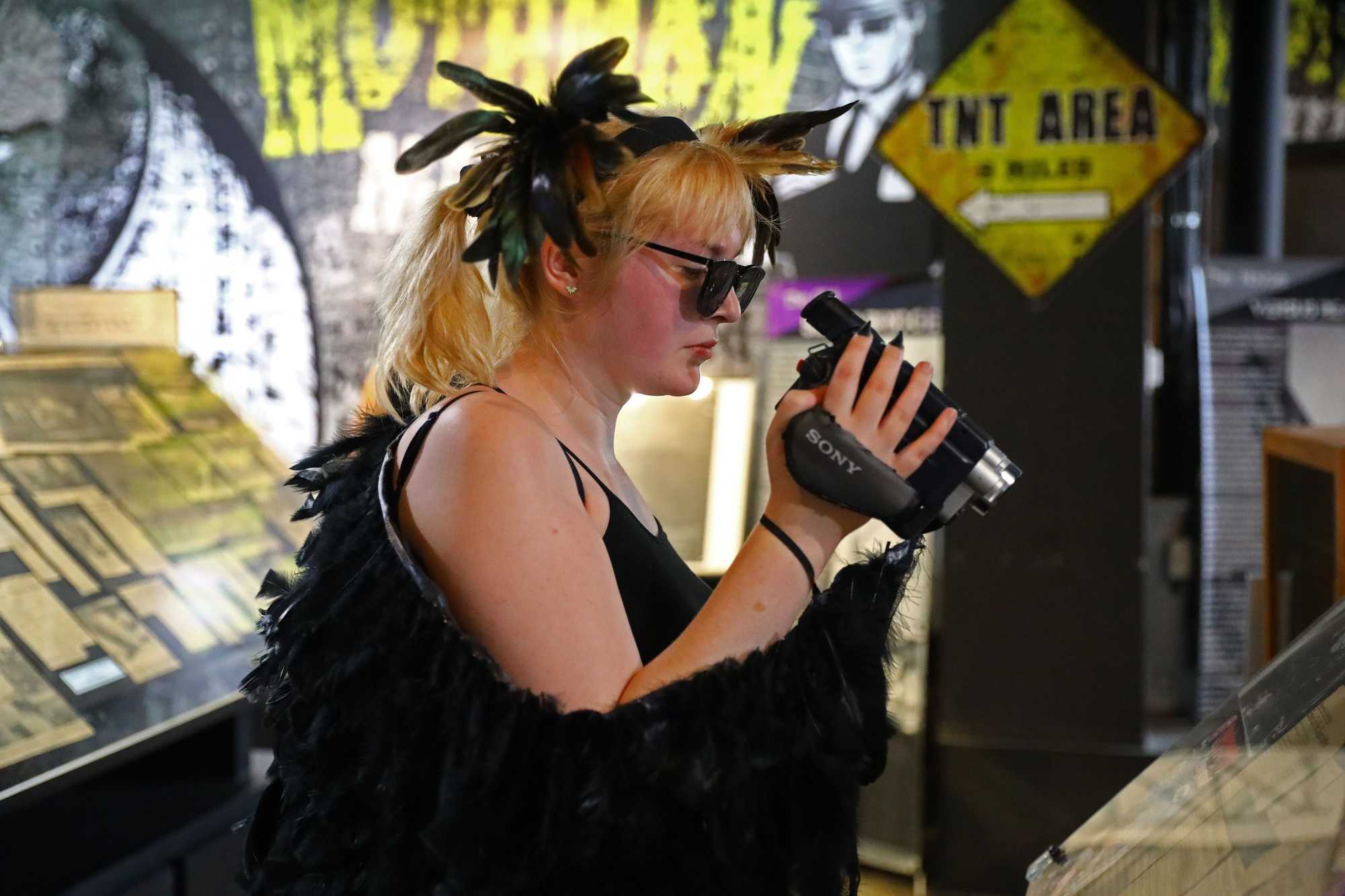 Dressed for the occasion, Theresa Schmidlin of Toledo, Ohio, recorded some artifacts in the Mothman Museum.  She traveled four hours to Point Pleasant to attend the Mothman Festival. 