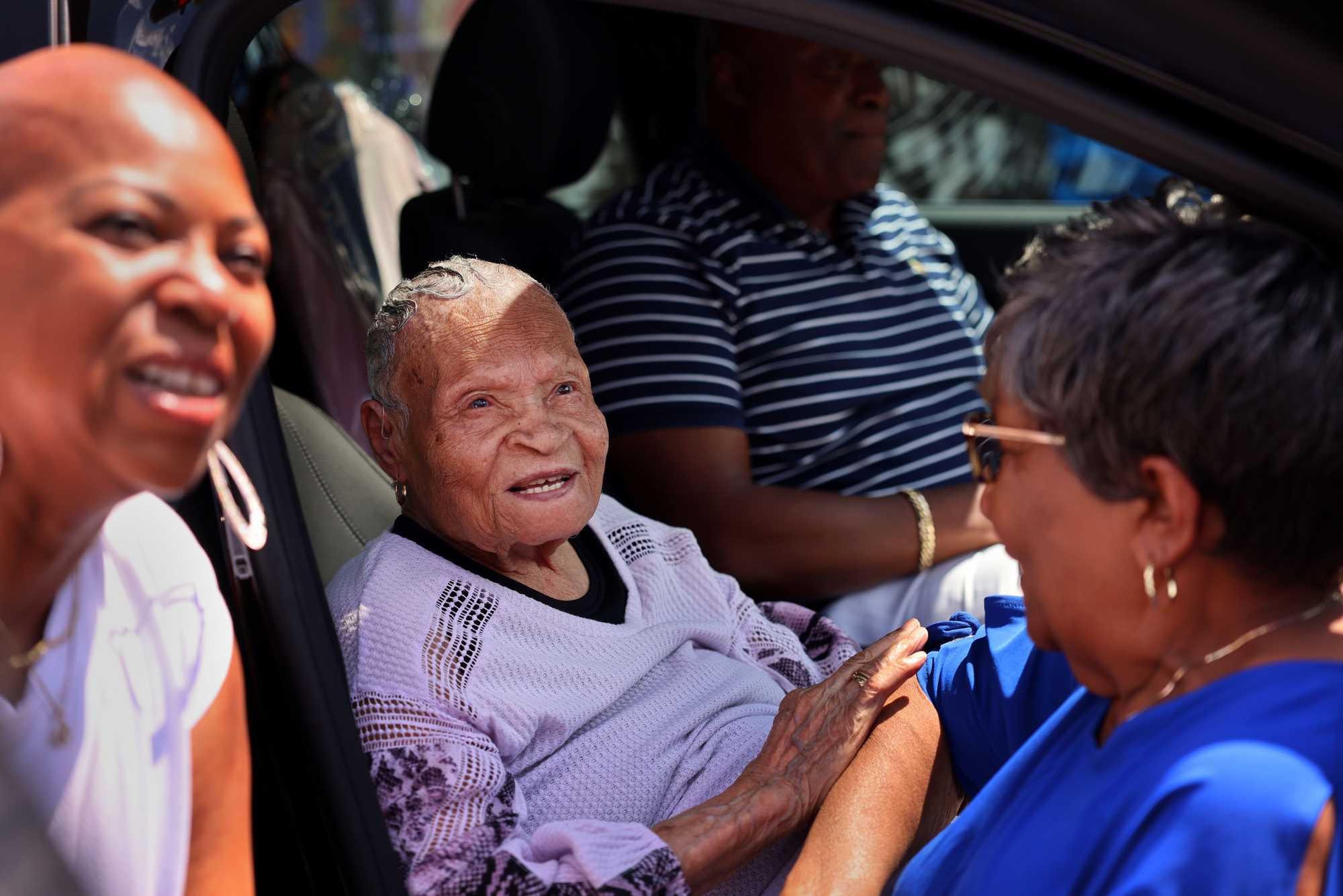 Viola Ford Fletcher (center) and her great-grandson, Ike Howard, talked with visitors in the Greenwood District on a September day. 