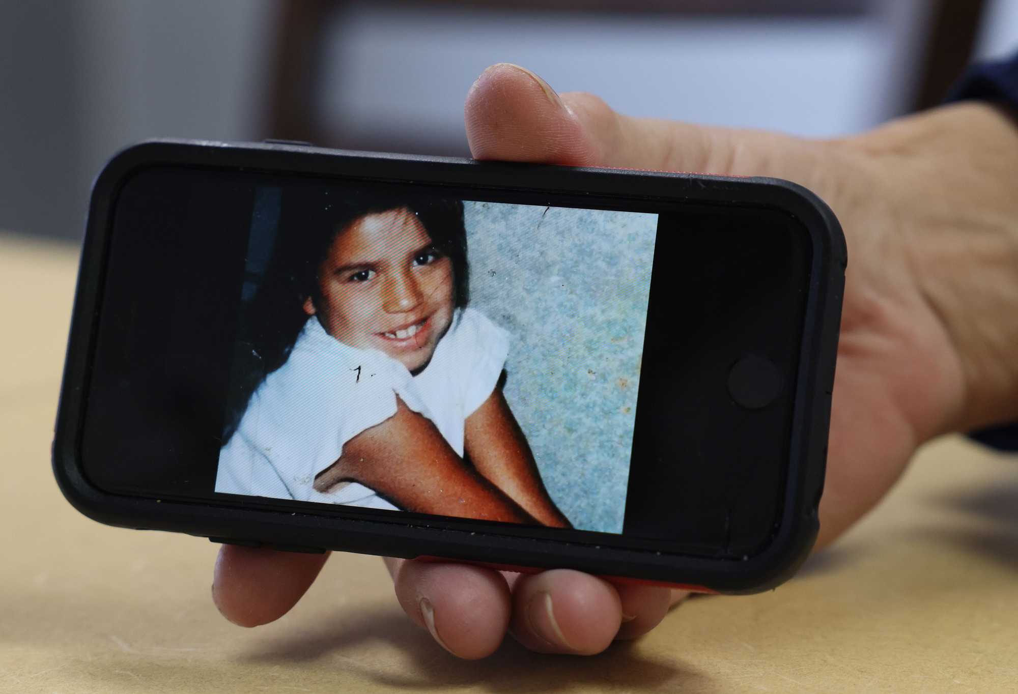 Jennifer White Bear held out her phone to show a childhood photo of her daughter, Bonnie Three Irons. 
