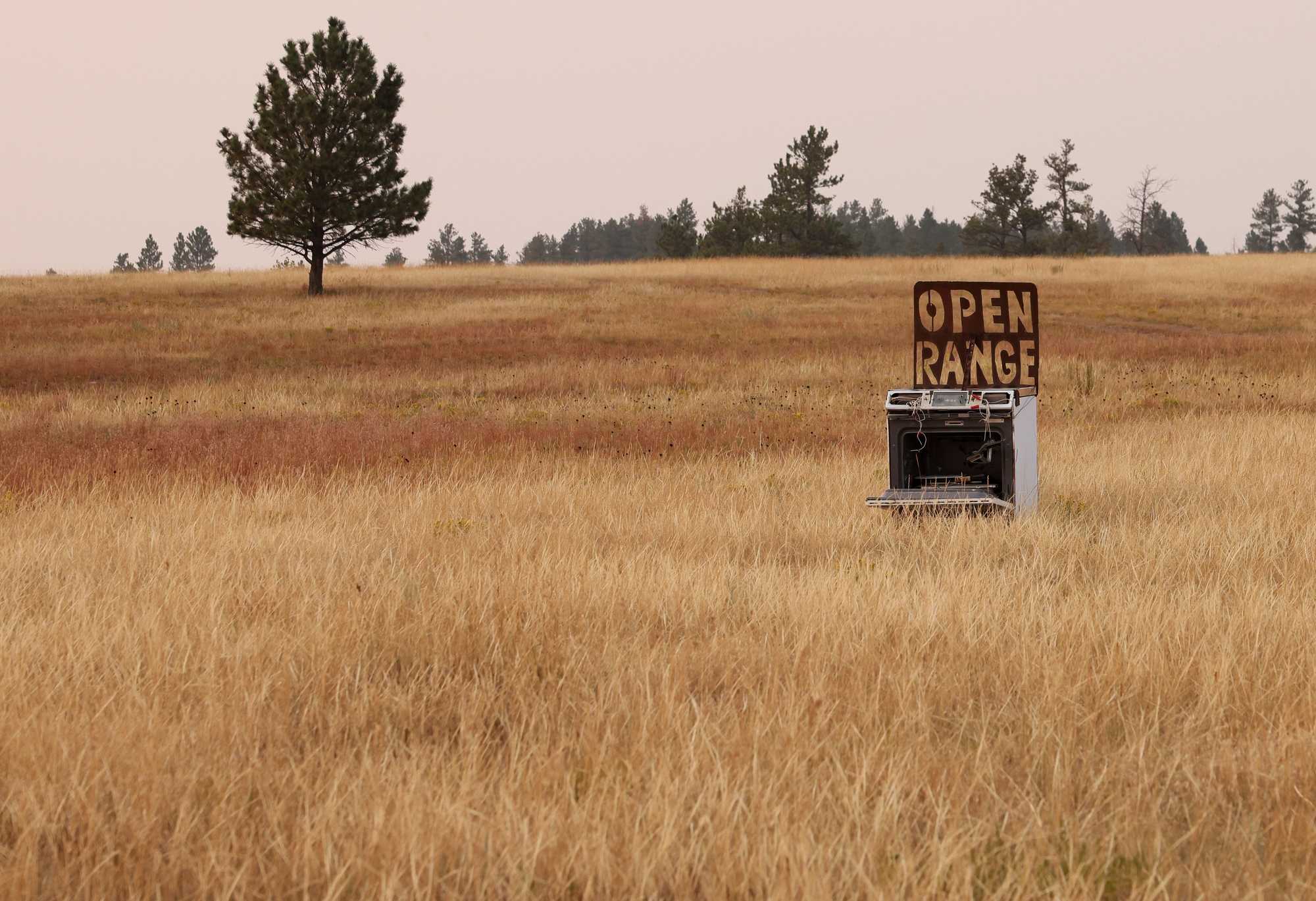 A comical sign rests in a field along Route 18 not far from the border of South Dakota and Wyoming.  